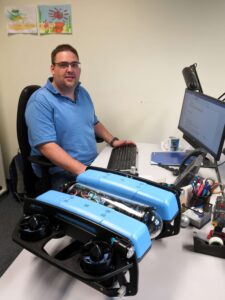 Christoph Tholen in seinem Büro mit einem der Unterwasserfahrzeuge, für das er Suchalgorithmen entwickelt.